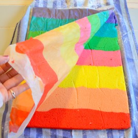 Peel wax paper off of rainbow cake