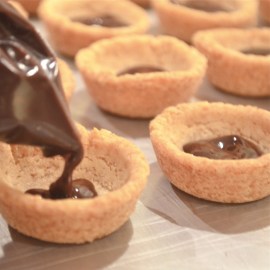 Piping chocolate into cookie cup